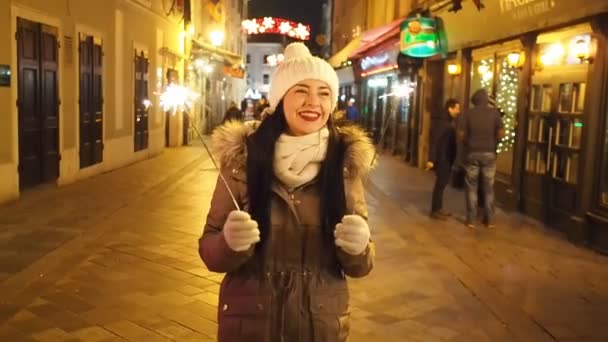 Young Smiling Woman Holding Burning Sparkler Cold Winter Evening Street — Stock Video