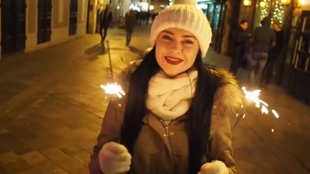 Young Smiling Woman Holding Burning Sparkler Cold Winter Evening Street — Stock Video