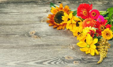 Tatil sonbahar buketi. Eski ahşap arka planda düzenlenmiş renkli çiçek çerçevesi. Reklam metniniz veya tanıtım içeriğiniz için üst görünüm ve kopyalama alanı.