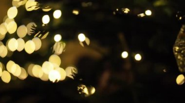 HD VIDEO 'daki Noel ağacının detayları. Süsler, ışıklar ve iğneler. Sığ alan derinliği ve bulanık arkaplan.