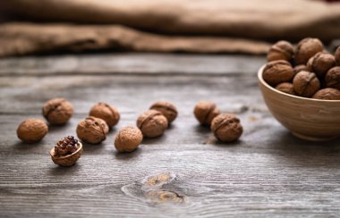 Bir kasede ceviz ve eski ahşap bir masada. Sağlıklı organik yiyecekler, biyoviands, doğal arka plan. Reklam metniniz için alanı kopyalayın.