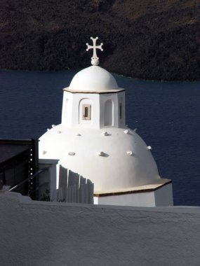 Typical urban landscape with a view of the church and the historical part of the town of Fira Santorini island,Greece. clipart