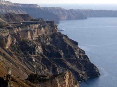 Yunanistan 'ın Santorini adasındaki Fira kasabasından dağların, denizin ve doğanın panoramik manzarası. Kalderanın ve körfezdeki gemilerin görüntüsü..