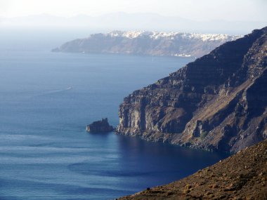 Yunanistan 'ın Santorini adasındaki Fira kasabasından dağların, denizin ve doğanın panoramik manzarası. Kalderanın ve körfezdeki gemilerin görüntüsü..