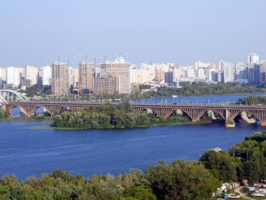 Dnipro Nehri manzarası, Kyiv Köprüsü ve Kyiv 'in sol kıyısı. Eski Sovyet apartmanları ve yeni lüks evler..