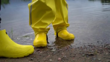 Büyük bir nehrin yavaşça yüzen dalgaları. Yağmurlu bir günde su yüzeyinde eşikler, taşlar ve dalgalar. Yağmurda köprüde balık tutarken.