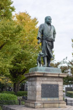 Tokyo, Japonya - 18 Kasım 2018: Heykel Saigo Takamoriand ve evde beslenen hayvan köpeği Tokyo'daki Ueno Park.