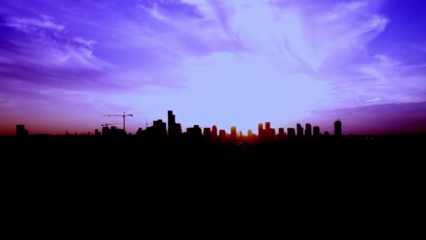 Gün batımında veya şafakta gökdelenleri olan bir metropoliten şehrin üstündeki mor siluet silueti. Hava aracı görüntüsü. — Stok video
