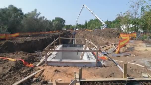 Luchtdrone boven bouwplaats openlucht in de natuur. Arbeiders met helmen langs industriële apparatuur voor de toewijzing van betoninfrastructuur — Stockvideo