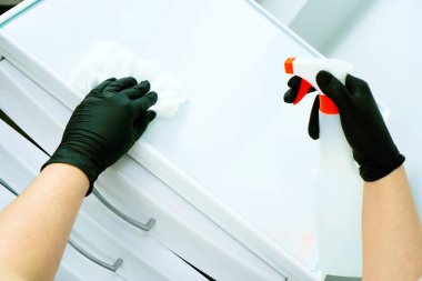 Bir dişçi doktoru elinde kauçuk bir baraj tutuyor. Tıbbi alet depolama dolabı. Dolap kayıyor.