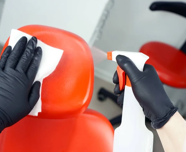 A dentist doctor holds a rubber dam in his hand. Medical tool storage cabinet. Sliding wardrobes