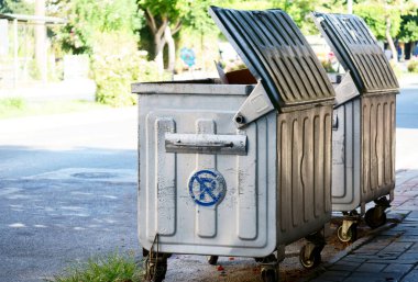 Bir şehir caddesinde gümüş renkli konteynırlar.