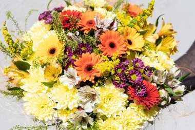 Renkli çiçek buketi aranjmanı. Çiçekçinin elinde tuttuğu yaz çiçekleri. Düğün ve mutlu günler için çiçekler..