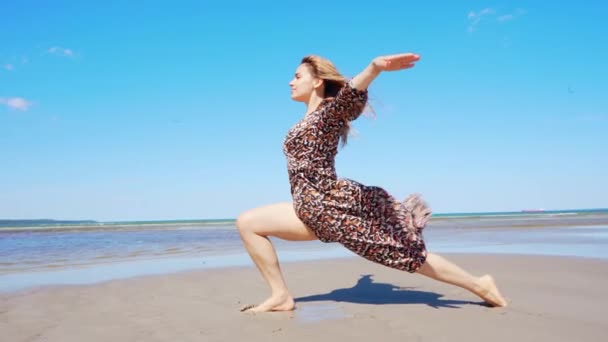 美丽的年轻女子在海滩上做瑜伽练习 在阳光灿烂的日子里度假的女孩感到自由 — 图库视频影像