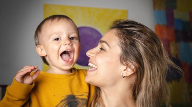 Anne ve oğlu birlikte aptalca oynuyorlar. Aile eğleniyor ve evde gülüyor.