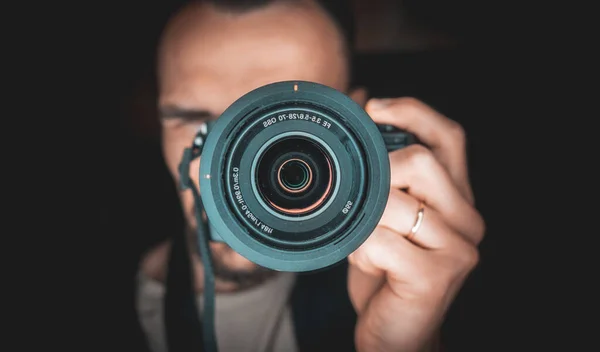 Man taking picutre of himself in the mirror. Huge camera lens in mirror