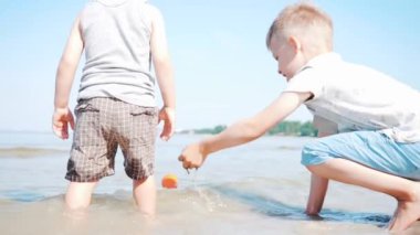 Güneşli bir günde plajda iki küçük kardeş birlikte oynuyorlar. Slow Motion çekimi. Aile Kavramı, Arkadaşlık, Eğitim, Keşif, Tatil, Yeni Hayat ve Aşk. 