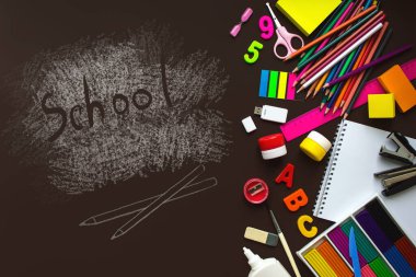 Karatahta geçmişinde okul malzemeleri olan bir çerçeve. Üst Manzara. Okul ve ofis malzemeleri çerçevesi