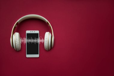 Modern cep telefonu ve kulaklıklar ses kaydı olan kırmızı gradyan arka planda şablon oluşturuyor. Müzik konsepti