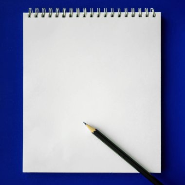 Mavi arka planda okul defteri ve kalem, okul konseptine dönüş, modern ilköğretim. düz yat