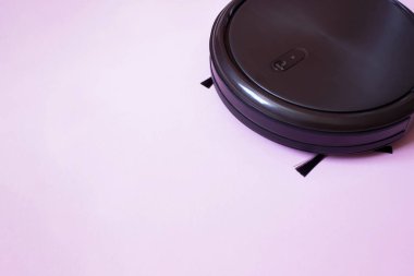 Robot elektrikli süpürge. Pembe arka planda Özerk Robotun Yakın Çekimi