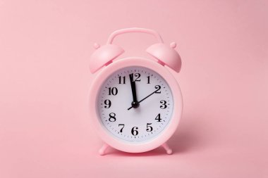 Pembe arka plandaki pastel pembe çalar saatler. Zaman kavramı. Minimum bileşim. Pembe Duvara Karşı Masadaki Alarm Saatinin Kapanışı