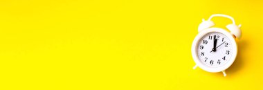 Renkli arka planda beyaz alarmlı saat. Moda minimal tarzı. Güzellik ve moda konsepti. Düz kompozisyon. Üst görünüm