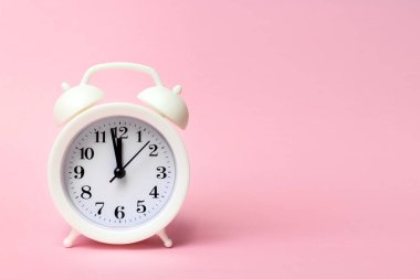 Renkli arka planda beyaz alarmlı saat. Moda minimal tarzı. Güzellik ve moda konsepti. Düz kompozisyon. Üst görünüm