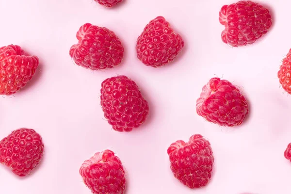 Raspberry candy pattern on pink background. Top view. Fresh raspberries background closeup. Ripe Delicious berries. Healthy food organic concept