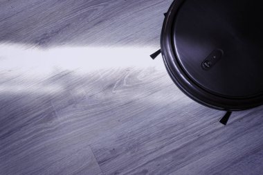 Selective focus of robotic vacuum cleaner washing parcet at night clipart