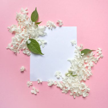 Kadınsı düğün, doğum günü kırtasiyesi taklit sahnesi. Beyaz yapraklı ve yeşil yapraklı boş tebrik kartı. Pembe arka plan. Düz yatış, üst görünüm