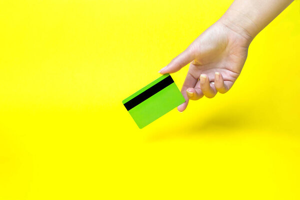 Hand holding business card, mockup, on yellow background