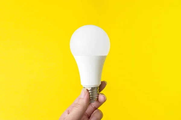 Led light bulb on a yellow background. New technology of energy, Eco power concept