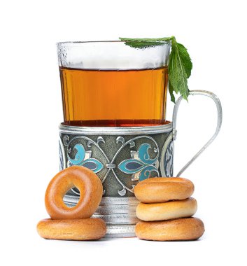 Bardakta sıcak çay ve beyaz arka planda simitli bir fincan.