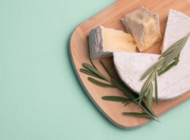 yeşil zemin üzerinde ahşap bir yüzey üzerinde camembert peyniri