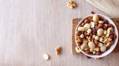 Tahta bir masada fındıklar. Ceviz, badem, fıstık, fındık ve kaju..