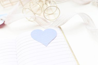 Turkuaz kalp. Arka planda ışıklar olan bir defter ve beyaz arkaplan aç.