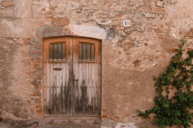 Ortaçağ cephesindeki kapı. Bu tarihi işareti koruyan bir ortaçağ kasabasında çekilmiş bir resim. Çok güzel ve resim gibi. Peratallada. İspanya 'da görülecek şeyler. Catalua 'da ne görüyorsun? Katalonya.