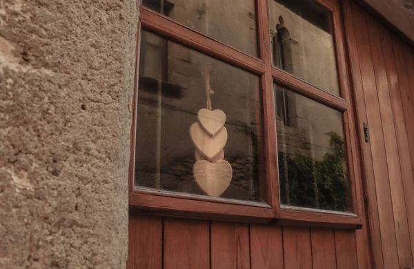 Wooden hearts hanging on a wooden window