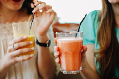 Meyve smoothies kızlarla bir kafede oturuyor. Kavram detoks.