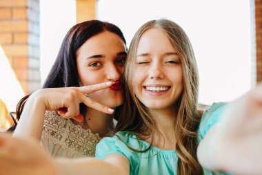 İki güzel, neşeli, gülümseyen kız selfie yapmak.