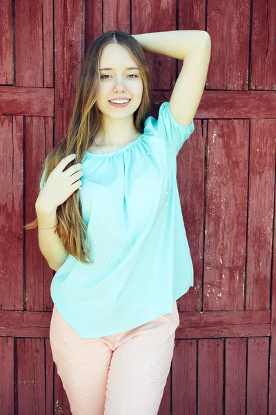 Krásná Dívka Modré Tričko Růžové Kalhoty Pozadí Dřevěné Dveře — Stock fotografie