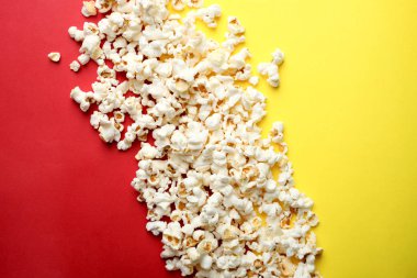 Tuzlu popcorn bir sarı ve kırmızı zemin üzerine. Üstten görünüm, kopya alanı.