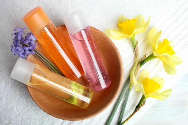 Drei Duschgel Und Schöne Blumen Auf Einem Frottee Handtuch — Stockfoto