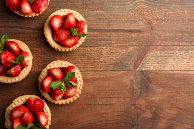 Tartlets ahşap arka plan üzerinde olgun çilek. Üstten görünüm.