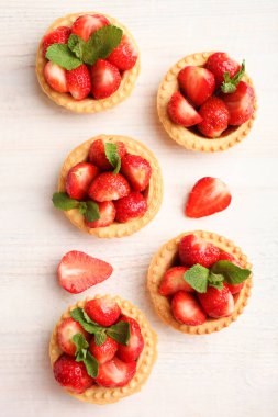 Ahşap arka plan üzerinde olgun çilek ile Tartlets. Üstten görünüm.