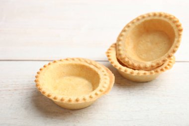 Ahşap arka plan üzerinde üç boş tartlets. Yan görünüm.