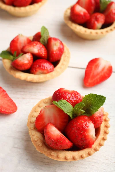 Ahşap arka plan üzerinde olgun çilek ile Tartlets. Yan görünüm.