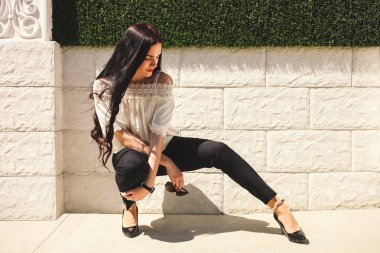 Duvar arka plan karşı klasik takım elbiseli güzel kız.