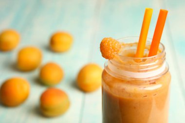 Bir şişe ve bir ahşap zemin üzerine kayısı kayısı smoothies.